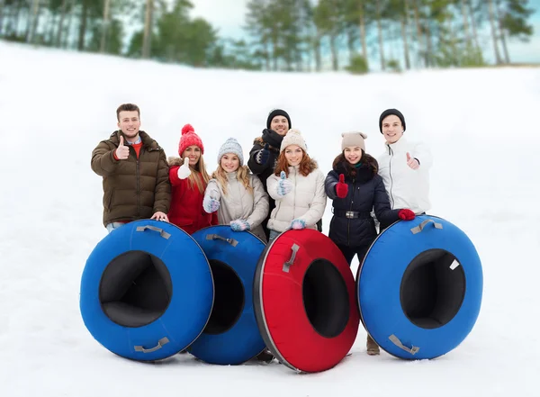 Groep lachende vrienden met sneeuw buizen — Stockfoto