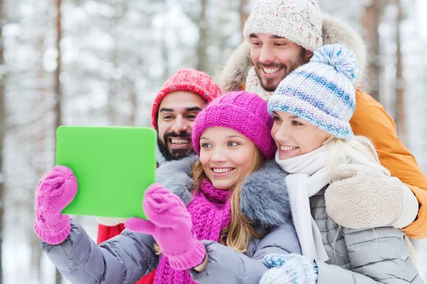 Amigos sonrientes con la tableta PC en el bosque de invierno — Foto de Stock