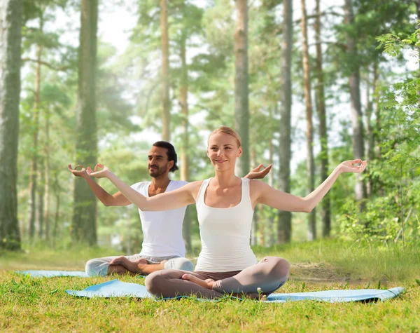 Glimlachend paar oefeningen maken yoga buiten — Stockfoto