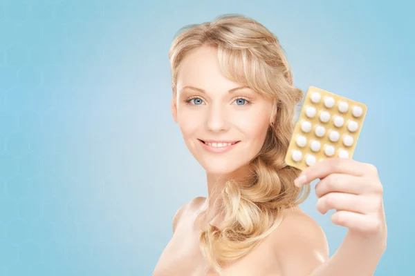 Счастливая молодая женщина держит пакет таблеток — стоковое фото