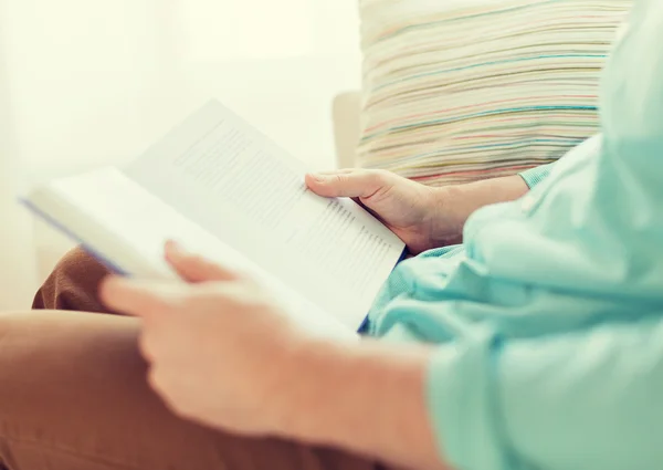 Close-up van de mens het lezen van boek thuis — Stockfoto