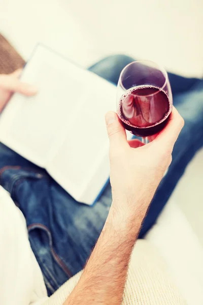 Mannenhand holdind boek en glas rode wijn — Stockfoto