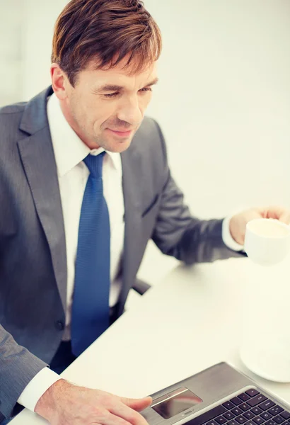 Empresário sorridente trabalhando com computador portátil — Fotografia de Stock