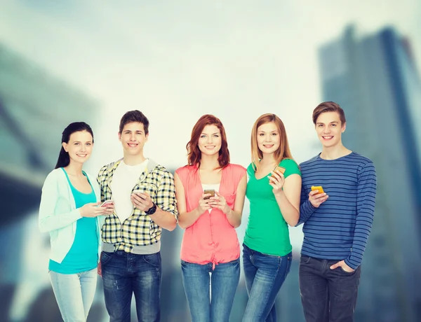 Smiling students with smartphones — Stock Photo, Image