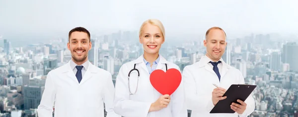 Grupp leende läkare med rött hjärta form — Stockfoto
