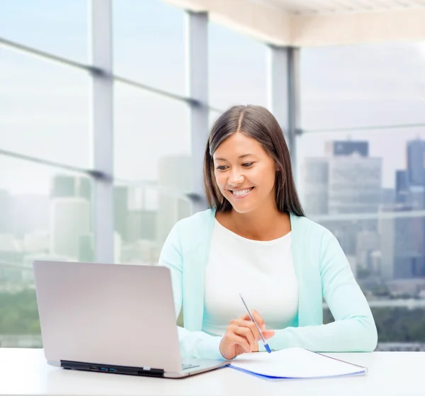 Smiling woman with laptop and notebook — Stock Photo, Image