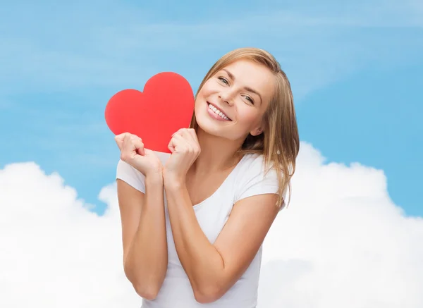 Mulher sorridente em t-shirt branca segurando coração vermelho — Fotografia de Stock
