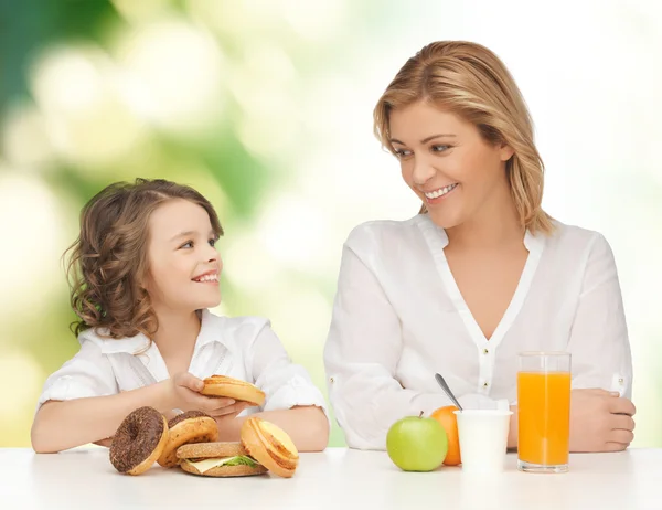 Mãe feliz e filha tomando café da manhã — Fotografia de Stock