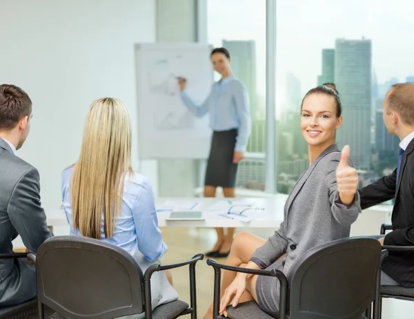 businesswoman with team showing thumbs up