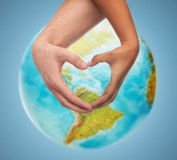 Human hands showing heart shape over earth globe — Stock Photo, Image