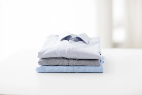 Close up of ironed and folded shirts on table — Stock Photo, Image