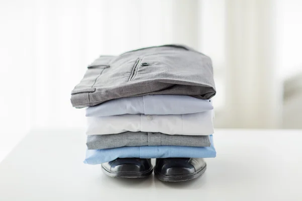 Primer plano de camisas masculinas, pantalones y zapatos en la mesa — Foto de Stock