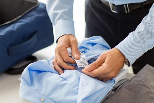Homem de negócios embalando roupas em saco de viagem — Fotografia de Stock