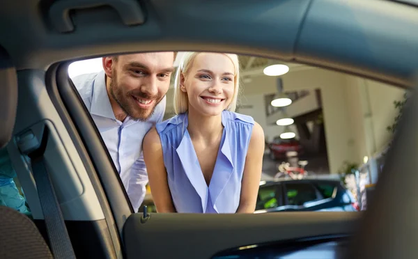 Feliz pareja comprando coche en auto show o salón —  Fotos de Stock