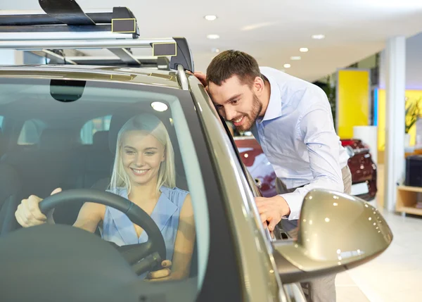 Feliz pareja comprando coche en auto show o salón — Foto de Stock