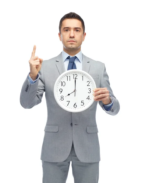 Επιχειρηματία στο κοστούμι, κρατώντας ρολόι με 8 oclock — Φωτογραφία Αρχείου