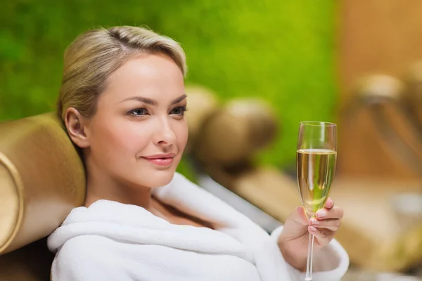 Beautiful young woman drinking champagne at spa — Stock Photo, Image