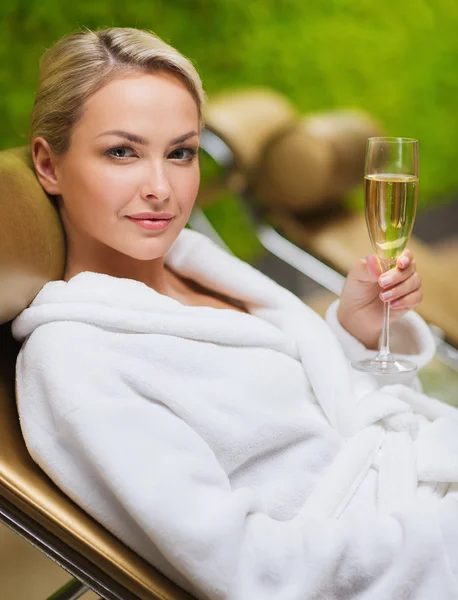 Beautiful young woman drinking champagne at spa — Stock Photo, Image