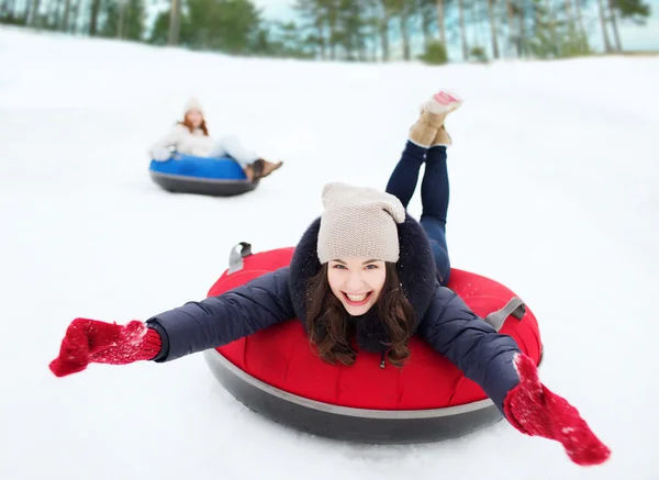 Groupe d'amis heureux glissant vers le bas sur des tubes à neige — Photo