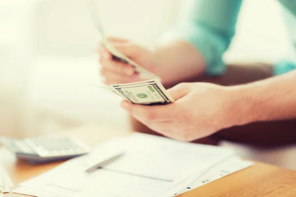 Close up of man counting money and making notes — Stock Photo, Image