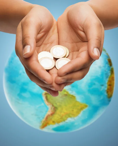 Kupade händer hålla euromynt över jorden världen — Stockfoto