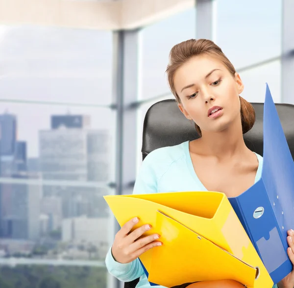 Young businesswoman with folders sitting in chair — Stock Photo, Image