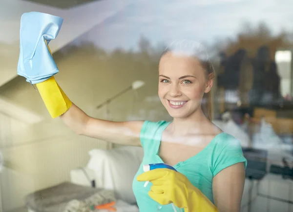 Mulher feliz em luvas janela de limpeza com pano — Fotografia de Stock