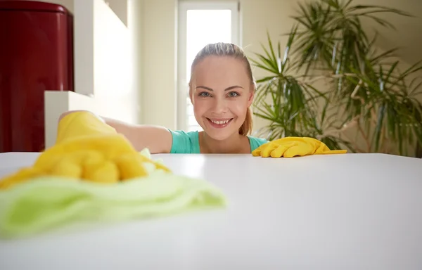 Lycklig kvinna rengöring bord på hem kök — Stockfoto