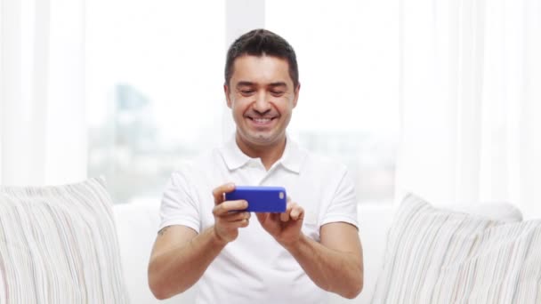 Homem feliz com smartphone em casa — Vídeo de Stock