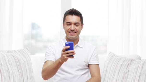 Hombre feliz con smartphone en casa — Vídeos de Stock