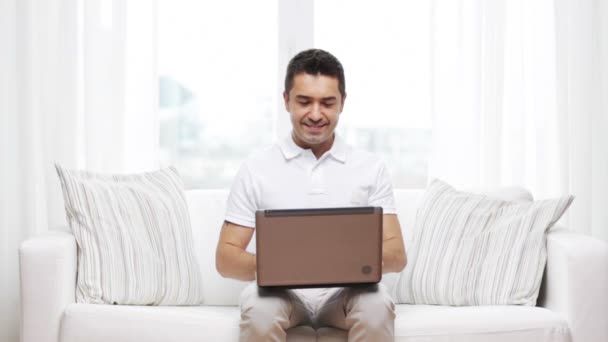 Happy man working with laptop computer at home — Stock Video