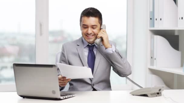 Улыбающийся бизнесмен с ноутбуком звонит по телефону — стоковое видео