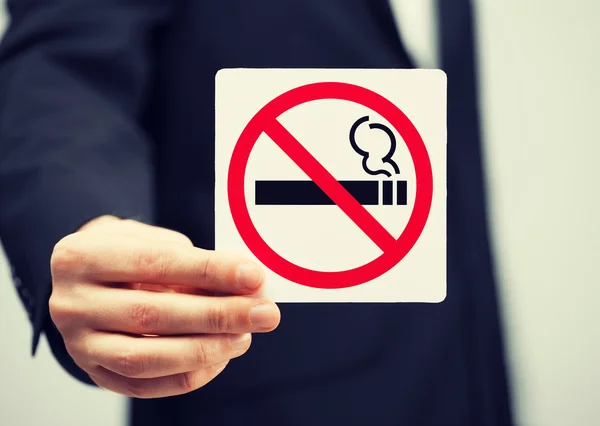 Man in suit holding no smoking sign — Stock Photo, Image