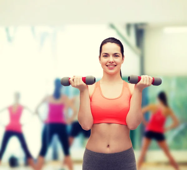 Jovem mulher esportiva com halteres leves — Fotografia de Stock