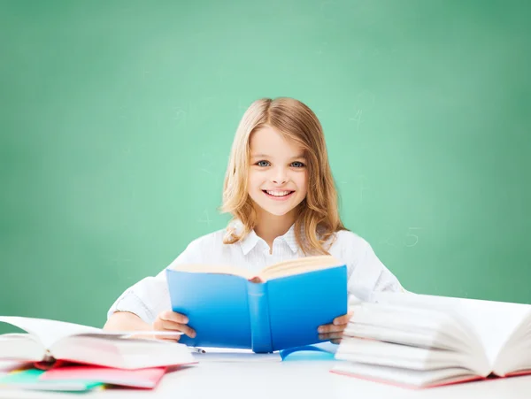 Feliz estudiante chica leyendo libro en la escuela — Foto de Stock