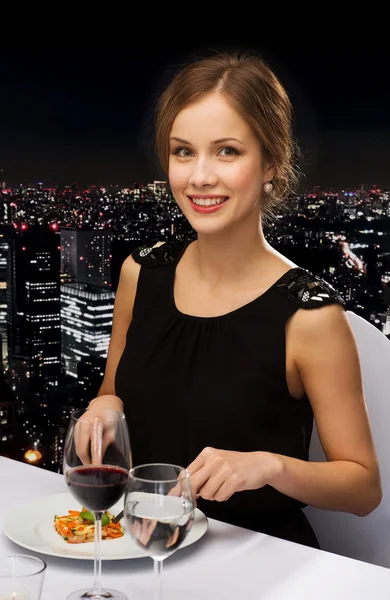 Smiling young woman eating main course — Stock Photo, Image