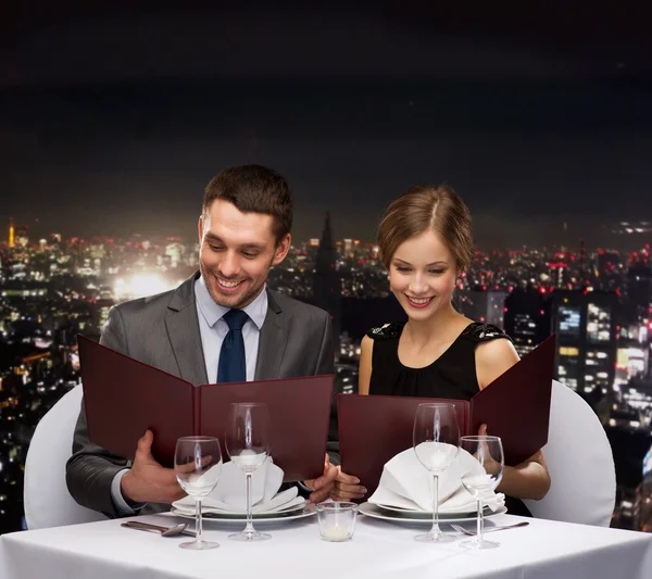 Улыбающаяся пара с меню в ресторане — стоковое фото