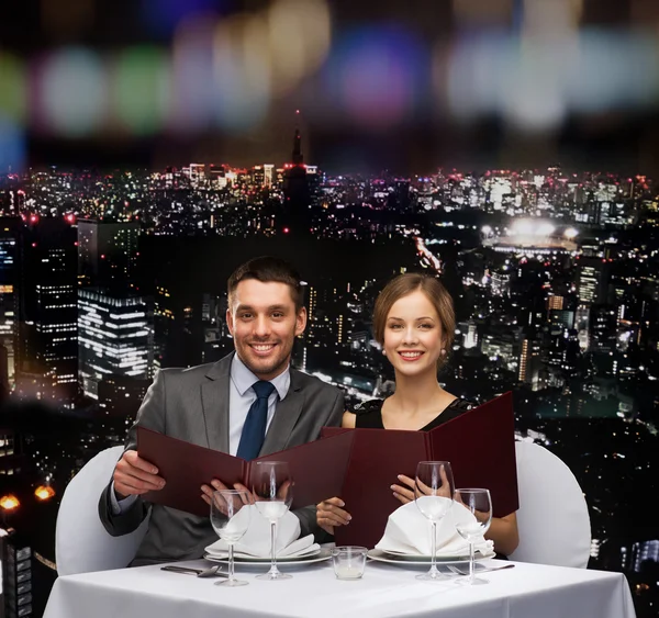 Casal sorrindo com menus no restaurante — Fotografia de Stock