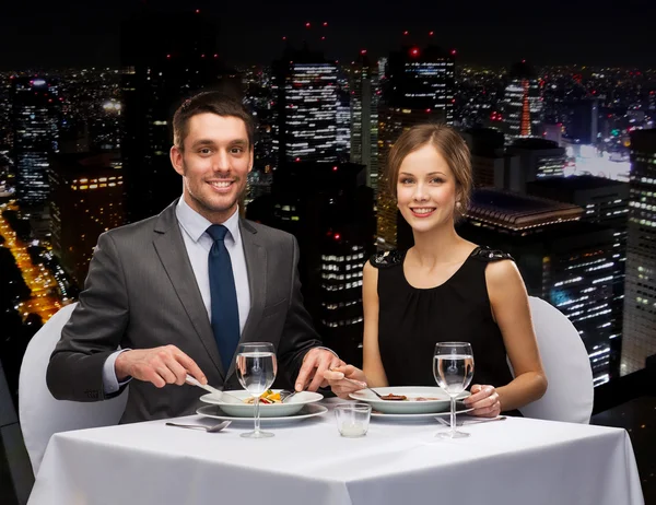 Lächelndes Paar isst Hauptgang im Restaurant — Stockfoto