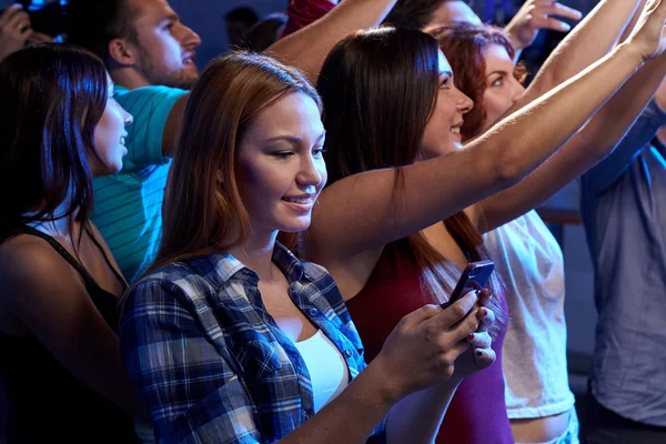 Woman with smartphone texting message at concert — Stock Photo, Image