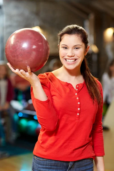 Jeune femme heureuse tenant le ballon dans le club de bowling — Photo