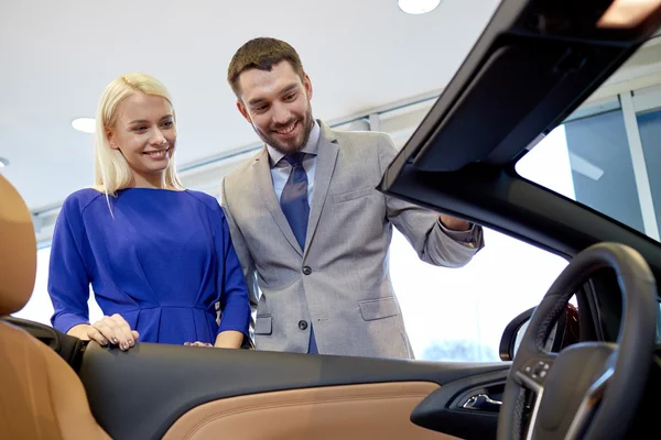 Casal feliz comprar carro em auto show ou salão — Fotografia de Stock