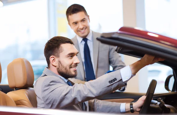 Glücklicher Mann mit Autohändler in Auto-Show oder Salon — Stockfoto