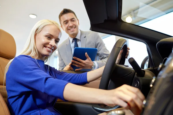 Mujer feliz con concesionario de coches en auto show o salón —  Fotos de Stock