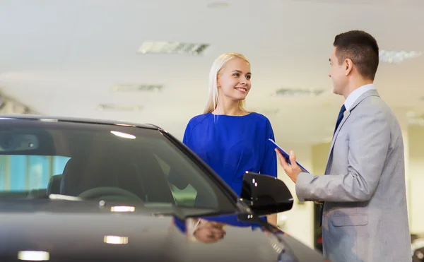 Glückliche Frau mit Autohändler in Auto-Show oder Salon — Stockfoto
