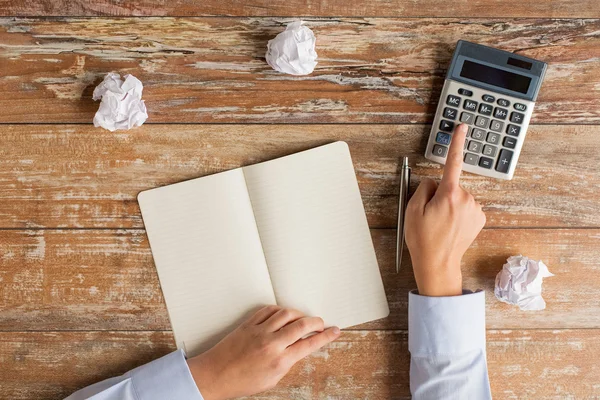 Close up of hands with calculator and notebook — Stock Photo, Image