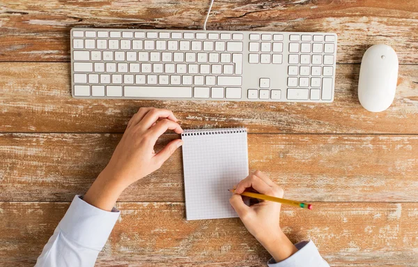 Primo piano delle mani con notebook e tastiera — Foto Stock