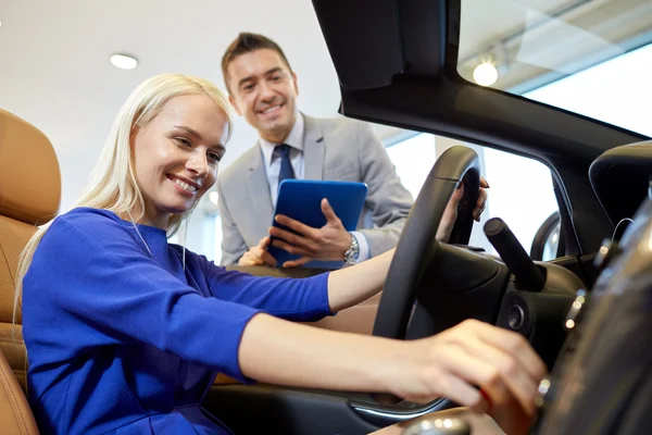 Mujer feliz con concesionario de coches en auto show o salón Imagen de archivo