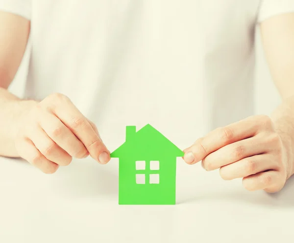 Mãos segurando casa verde — Fotografia de Stock