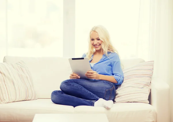 Donna sorridente con computer tablet pc a casa — Foto Stock